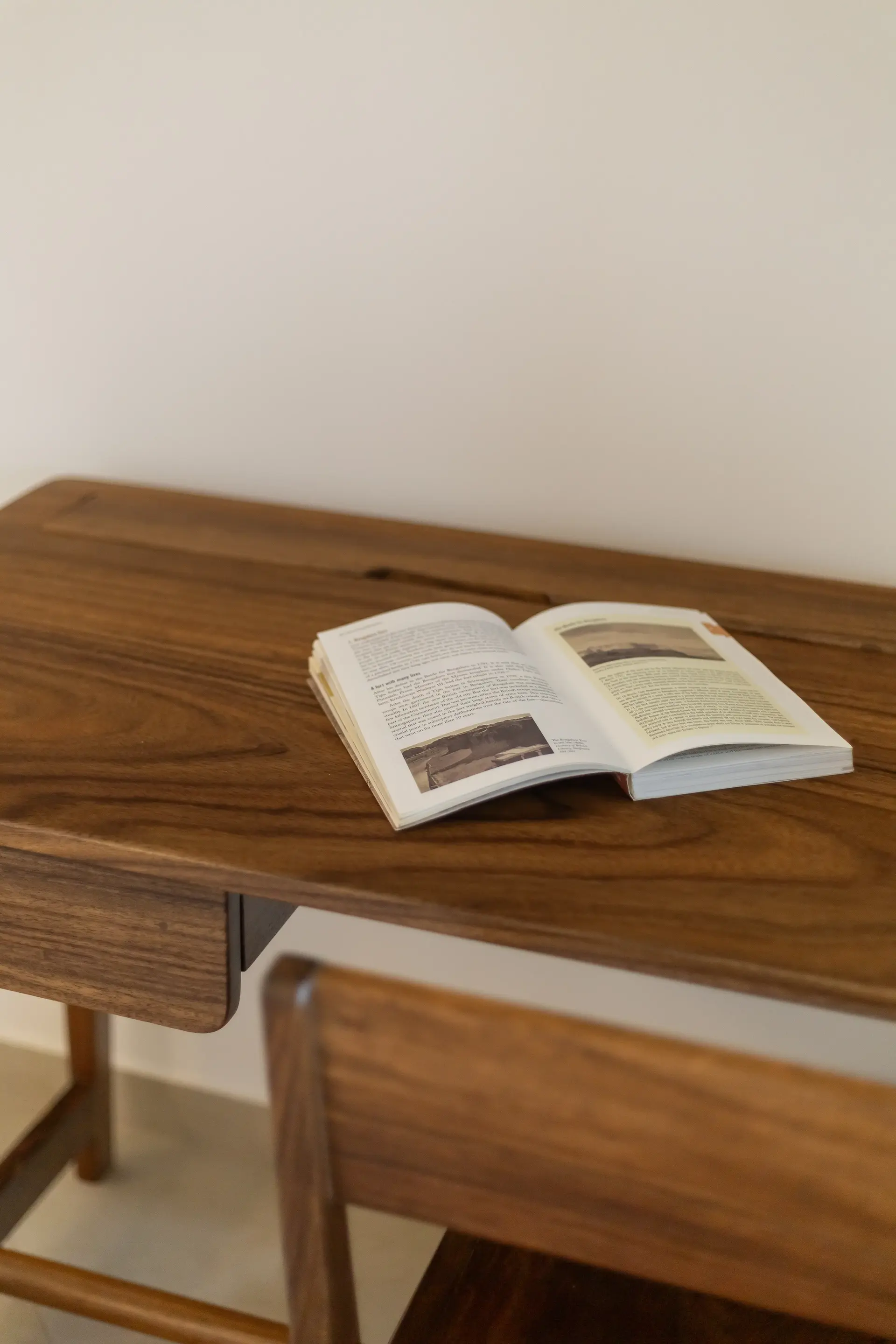Wooden study table with an open book and a wooden chair